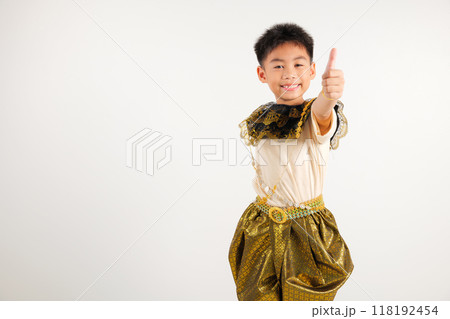 Portrait Thailand kid boy smiling traditional Thai dress costume makes thumbs up OK sign, symbolizing agreement, studio isolated white background, primary child radiates positivity and satisfaction Portrait Thailand kid boy smiling traditional Thai dress costume makes thumbs up OK sign, symbolizing agreement, studio isolated white background, primary child radiates positivity and satisfaction 118192454