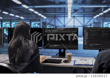 Software developer checking for signs of imminent failure in data center equipment. IT professional working at PC desk to preventing server rows damages, monitoring critical systems 118193217