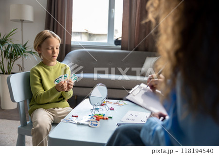 Cute blonde boy having a session of speech exercises with speech therapist 118194540