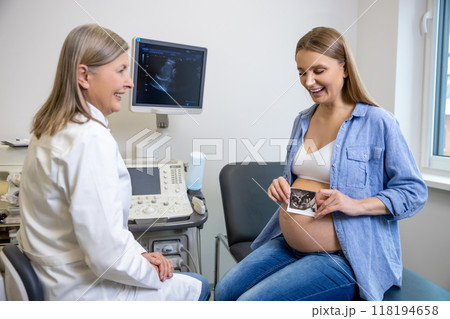Doctor talking to a pregnant patient after ultrasonography 118194658