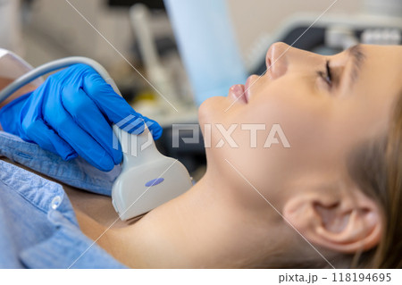 Young woman having an ultrasonography procedure on her thyroid gland Young woman having an ultrasonography procedure on her thyroid gland 118194695