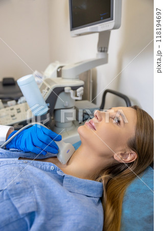 Young woman having an ultrasonography procedure on her thyroid gland 118194697