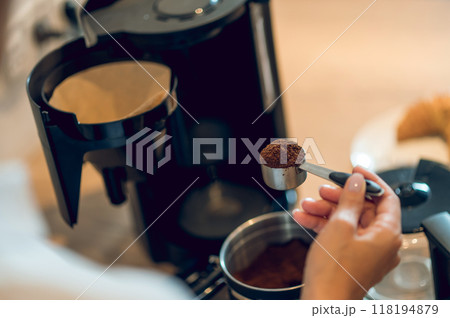 Close up of womans hand with a full spoon of coffee 118194879