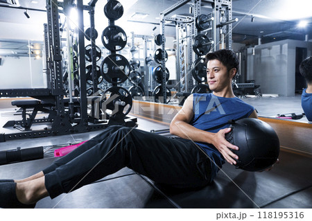 スポーツジムでトレーニングする男性　腹筋　メディシンボール 118195316