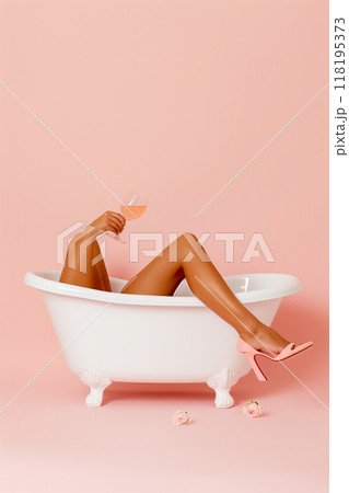 A woman is in a bathtub with a glass of wine in her hand 118195373