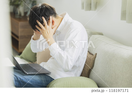 リビングでパソコンを使う男性 118197171