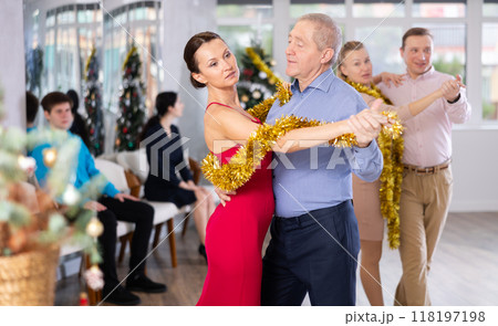 Couples dancing during Christmas - men and women dancing tango or samba next to Christmas tree Couples dancing during Christmas - men and women dancing tango or samba next to Christmas tree 118197198