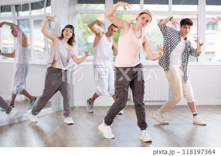 Active group sporty people practicing hip-hop dance in training hall during dancing classes 118197364