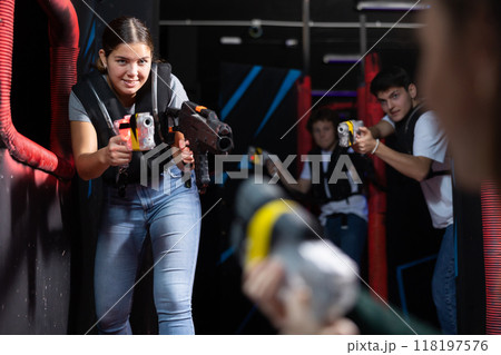 Girl running and dodging while playing lasertag Girl running and dodging while playing lasertag 118197576