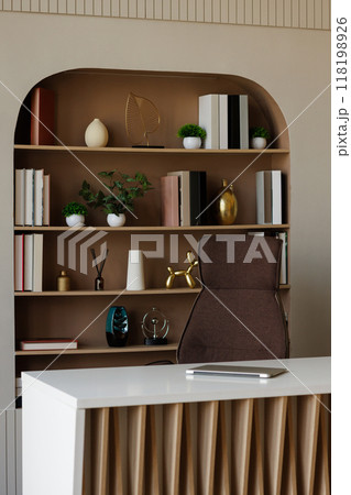 Interior of a study room with a brown bookshelf and a chair in front of it. Interior of a study room with a brown bookshelf and a chair in front of it. 118198926