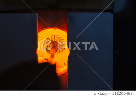 Open furnace with molten glass on a blowpipe inside, glass blowing Open furnace with molten glass on a blowpipe inside, glass blowing 118200468
