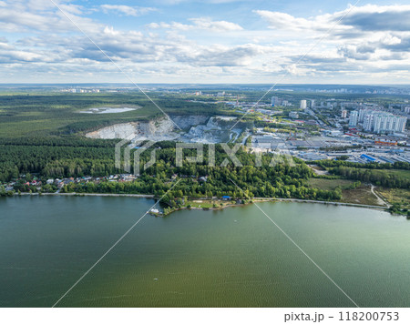 Stone quarry in the forest. Flying over the summer mixed forest during sunset. The surroundings of Yekaterinburg. Ural, Russia, Aerial View 118200753