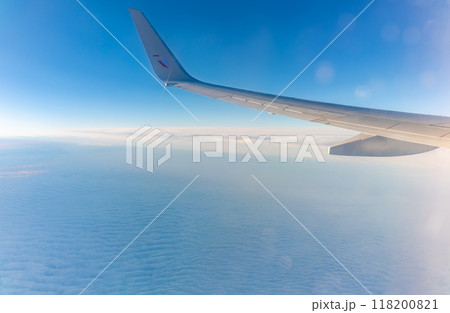View from the airplane window at a beautiful cloudy sky and the airplane wing View from the airplane window at a beautiful cloudy sky and the airplane wing 118200821
