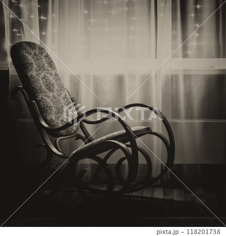A rocking chair by the window 118201738