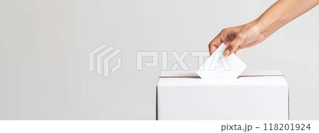 Civic duty - hand placing a ballot paper in ballot box for voting, emphasizing importance of election concept, showcasing anonymity of secret ballot, reflecting competitive nature of preelection race. Civic duty - hand placing a ballot paper in ballot box for voting, emphasizing importance of election concept, showcasing anonymity of secret ballot, reflecting competitive nature of preelection race. 118201924