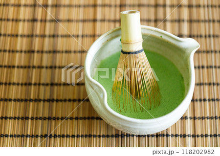 Cup of fresh matcha tea, green tea on wooden mat background. Selective focus. 118202982