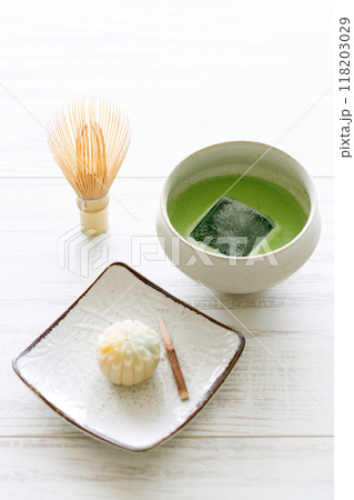 Cup of fresh matcha tea, green tea and Japanese confectionary on white wooden table. Cup of fresh matcha tea, green tea and Japanese confectionary on white wooden table. 118203029
