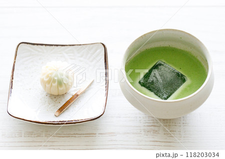 Cup of fresh matcha tea, green tea and Japanese confectionary on white wooden table. Cup of fresh matcha tea, green tea and Japanese confectionary on white wooden table. 118203034