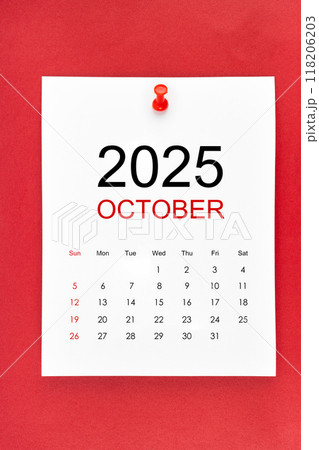 October 2025 calendar page with push pin on red background. October 2025 calendar page with push pin on red background. 118206203