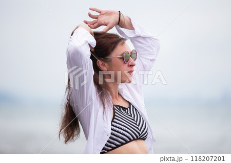 A beautiful middle-aged woman is relaxing at a resort, walking and enjoying her vacation. A beautiful middle-aged woman is relaxing at a resort, walking and enjoying her vacation. 118207201