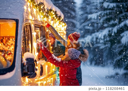 Family Decorating a Camper Van with Christmas Lights in the Snow 118208461