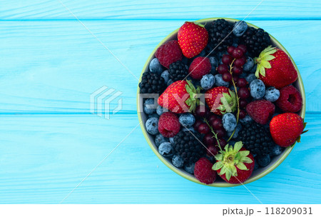 Mix of ripe colorful berries in bowl photography . Blueberry , strawberry , raspberry , blackberry and red currant . Top view 118209031