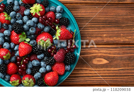 Mix of ripe colorful berries in bowl photography . Blueberry , strawberry , raspberry , blackberry and red currant . Top view 118209038