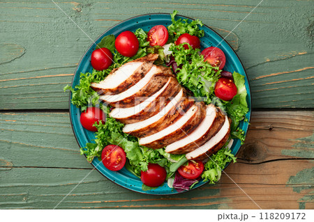 Grilled chicken breast ( fillet ) with lattuce salad and cherry tomatoes . Top view 118209172