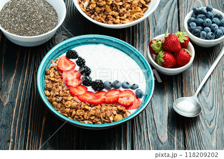 Healthy breakfast . Yogurt with berries ( strawberry , raspberry , blueberry , blackberry ) , granola and chia seeds . Top view Healthy breakfast . Yogurt with berries ( strawberry , raspberry , blueberry , blackberry ) , granola and chia seeds . Top view 118209202