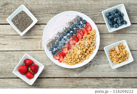 Healthy breakfast . Yogurt with berries ( strawberry , raspberry , blueberry , blackberry ) , granola and chia seeds . Top view Healthy breakfast . Yogurt with berries ( strawberry , raspberry , blueberry , blackberry ) , granola and chia seeds . Top view 118209222