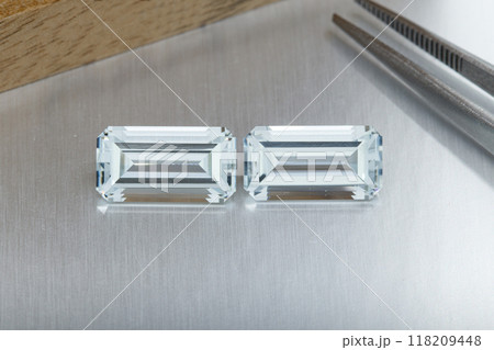 macro mineral faceted stone aquamarine with tweezers on a gray background macro mineral faceted stone aquamarine with tweezers on a gray background 118209448