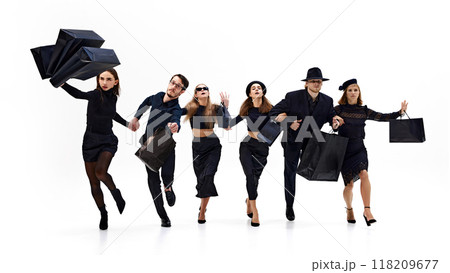 Group of fashion forward people, running, while holding their shopping bags, expressing excitement against white background. 118209677