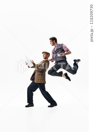 With dynamic leap, one man reads his paper as another leaps beside him against white studio background. Blend of news and trends. With dynamic leap, one man reads his paper as another leaps beside him against white studio background. Blend of news and trends. 118209730