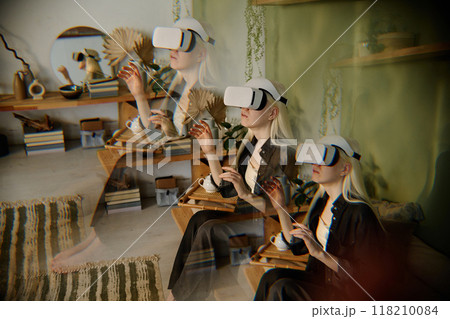Multiple exposure shot of girl with albinism experiencing virtual reality via headset device while spending time at home 118210084