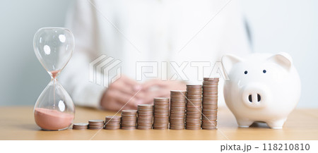Money Saving for Future Plan, Retirement fund, Pension, Investment, Wealth Business and Financial concepts. coins stack, piggy bank with sandglass on table 118210810