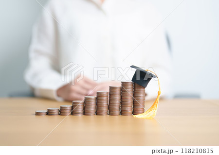 Money saving for Education, Scholarship, Student loan and debt and study future plan concept. Coins stack growing up with graduation hat on table 118210815