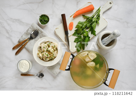 Overhead view of pelmeni cooked in vegetable broth on marble tabletop Overhead view of pelmeni cooked in vegetable broth on marble tabletop 118211642
