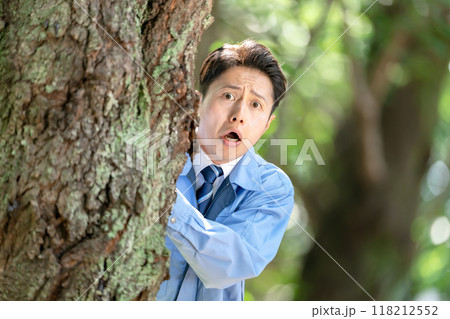 木の隠れる作業着を着た男性 木の隠れる作業着を着た男性 118212552