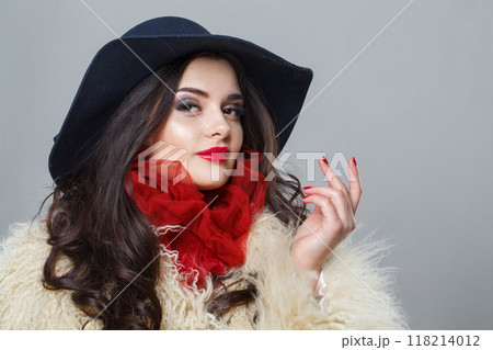 Attractive woman with red lips make-up and long wavy hair wearing blue hat Attractive woman with red lips make-up and long wavy hair wearing blue hat 118214012
