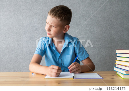 Young Boy Concentrating on Reading Books at Desk. International Dysgraphia Awareness Day Young Boy Concentrating on Reading Books at Desk. International Dysgraphia Awareness Day 118214173