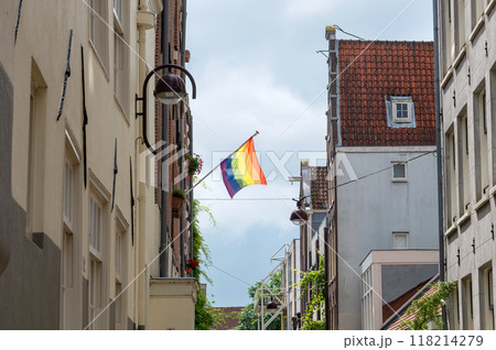 Pride flag hanging on building in a narrow European street 118214279