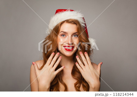 Portrait of happy excited surprised Christmas woman in Santa hat with make-up and manicure nail  118214344