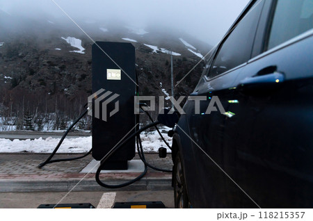 Using a charging station. Renewable energy concept. Electric car using sustainable source. Saving, climate change Using a charging station. Renewable energy concept. Electric car using sustainable source. Saving, climate change 118215357