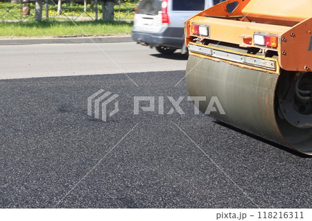 Asphalt road roller press new hot asphalt on the roadway on a road construction site. Heavy Asphalt road roller press new hot asphalt on the roadway on a road construction site. Heavy 118216311