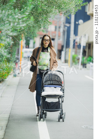 赤ちゃんを抱いて歩く母親　 118218453