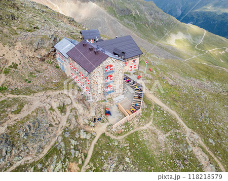 The Breslauer Hut rests peacefully in the Otztal Alps, surrounded by rugged mountain terrain. Visitors gather outside, enjoying the breathtaking alpine views during a sunny day in the Austrian The Breslauer Hut rests peacefully in the Otztal Alps, surrounded by rugged mountain terrain. Visitors gather outside, enjoying the breathtaking alpine views during a sunny day in the Austrian 118218579