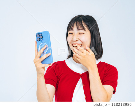 スマホを見て笑う女の子 118218986