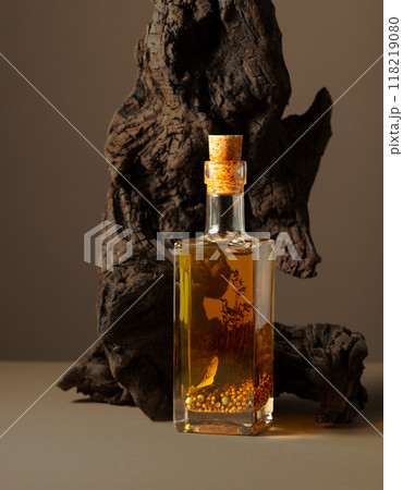 Bottle of spicy olive oil and olive tree snag on a beige background. Bottle of spicy olive oil and olive tree snag on a beige background. 118219080