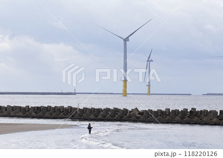 海岸沿いに並んだ風力発電と釣り人 118220126