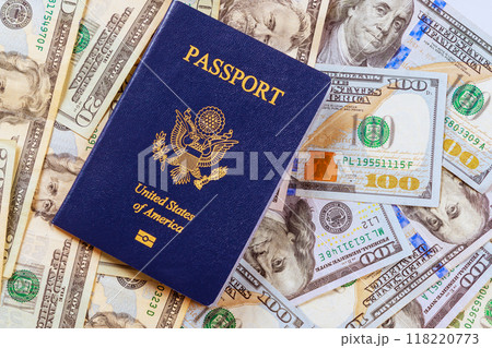 An American passport on top American dollar cash banknote of different denomination An American passport on top American dollar cash banknote of different denomination 118220773